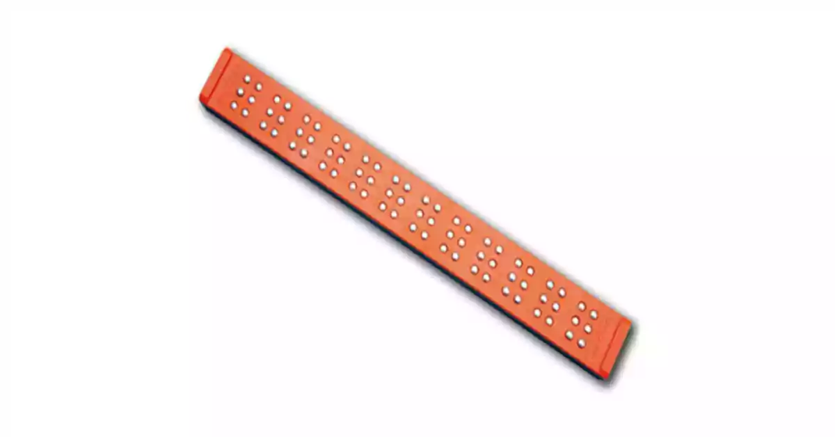 Rágua Braille laranja com orifícios para colocar pinos para formar caracteres Braille