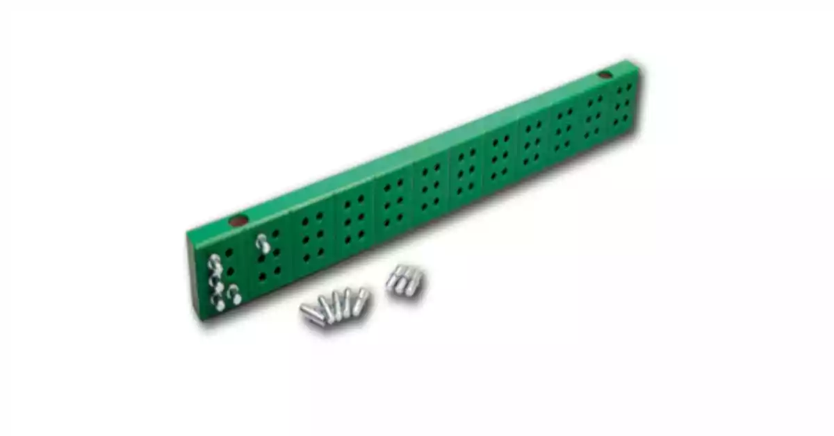 Régua Braille verde com orifícios e pinos metálicos para formação de caracteres