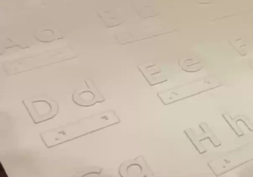 Folha plástica com as letras do alfabeto em relevo e a respetiva correspondência em Braille