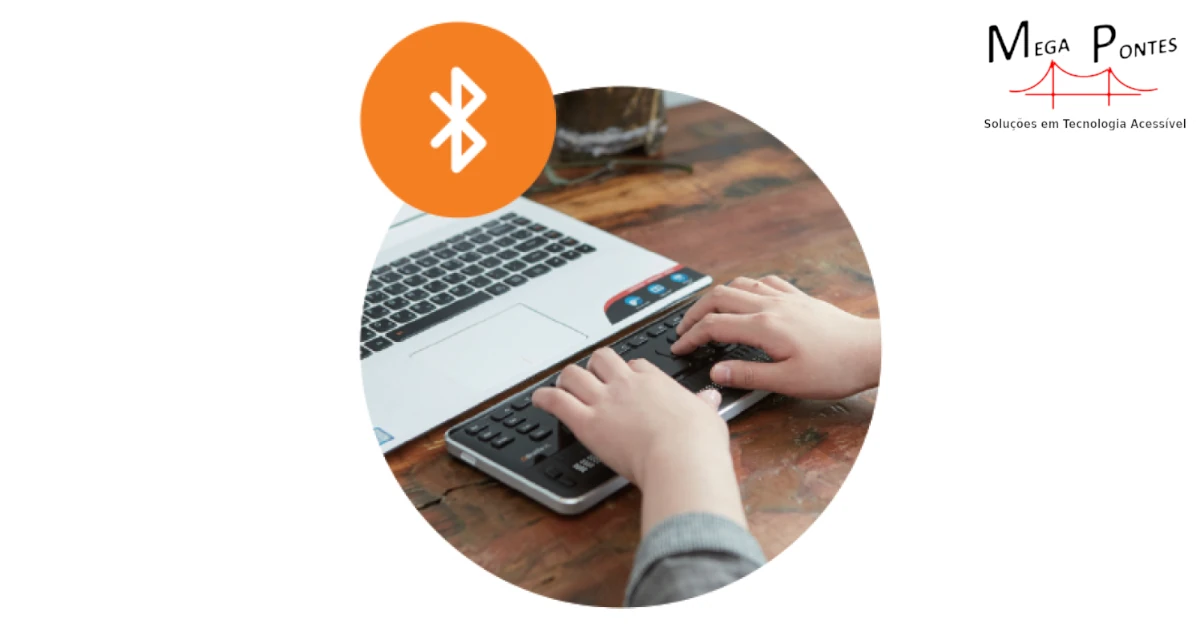 Pessoa sentada à secretária a utilizar a QBraille XL 40 para controlar o computador portátil